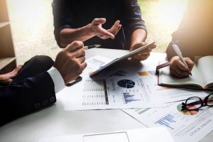 Co-managed IT Support Georgetown Business people using pen,tablet,notebook are planning a marketing plan to improve the quality of their sales in the future.
