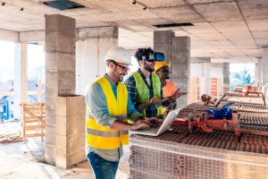 Architect & Engineer working and talking about project planning and progress of work schedule on the home building construction site. Caucasian man using wearing virtual reality glasses or goggles virtually discovering new flat, buying and selling homes in Virtual reality.